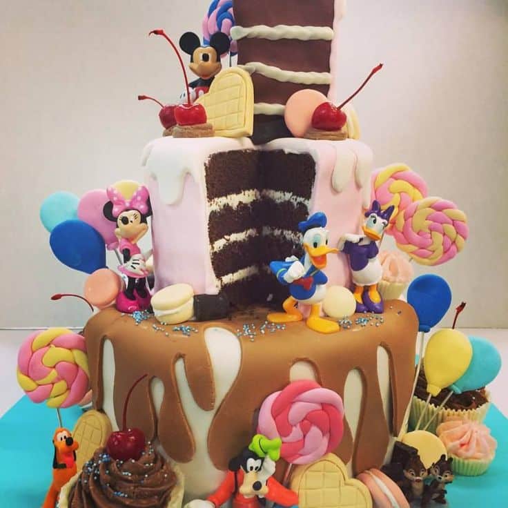 Disney decorations and fondant candies on this over the top cake ...