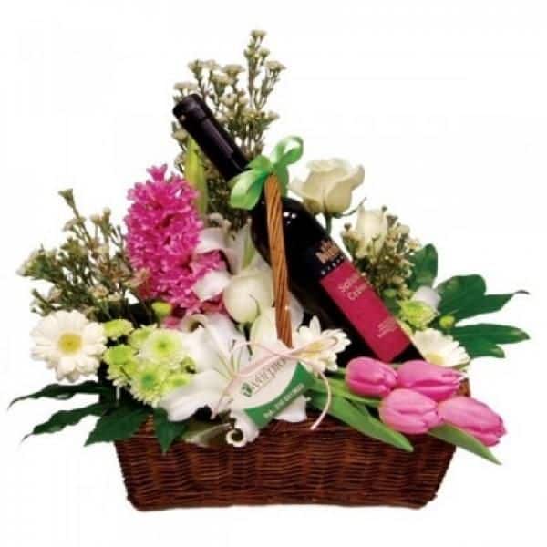GIFT BASKET, WITH FLOWERS AND A BOTTLE OF WINE.